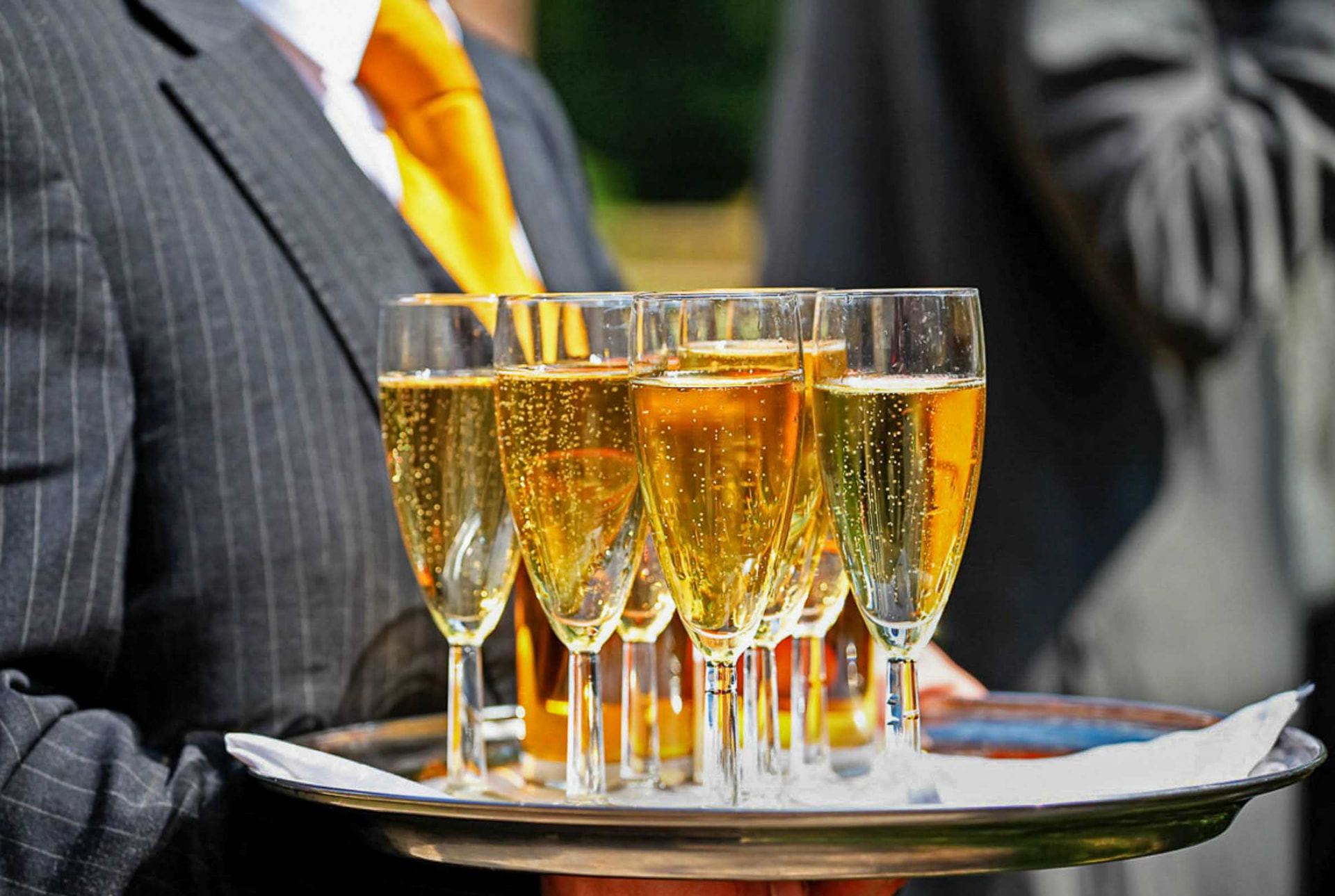 Waiter carrying a tray of champagne flutes at a South Wales wedding reception